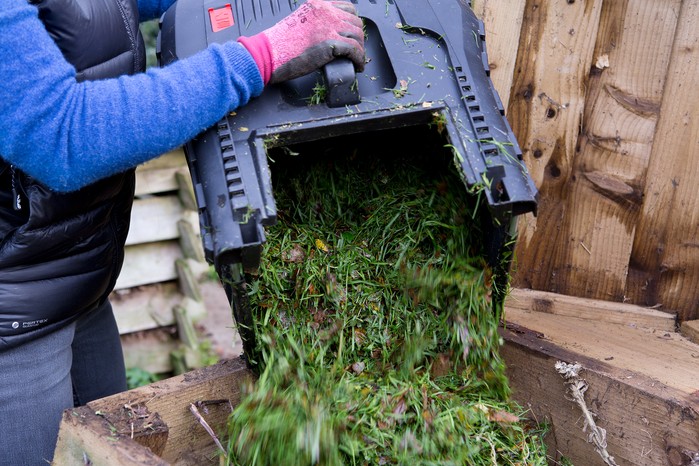 Emptying a lawn clippings bag. Sarah Cuttle