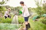 Woman watering plants in allotment. Getty Images.