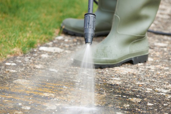 Using a pressure washer to clean a patio. Getty Images