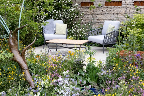 Garden patio with comfy furniture and generous planting. Paul Debois