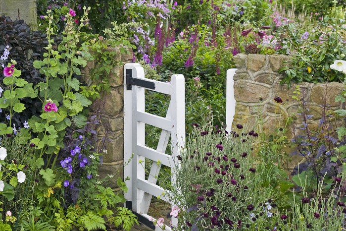 Front garden with white gate and cottage-style planting