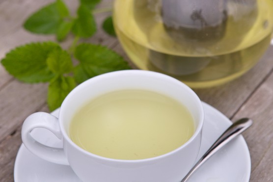 A pot and cup of fresh herbal tea